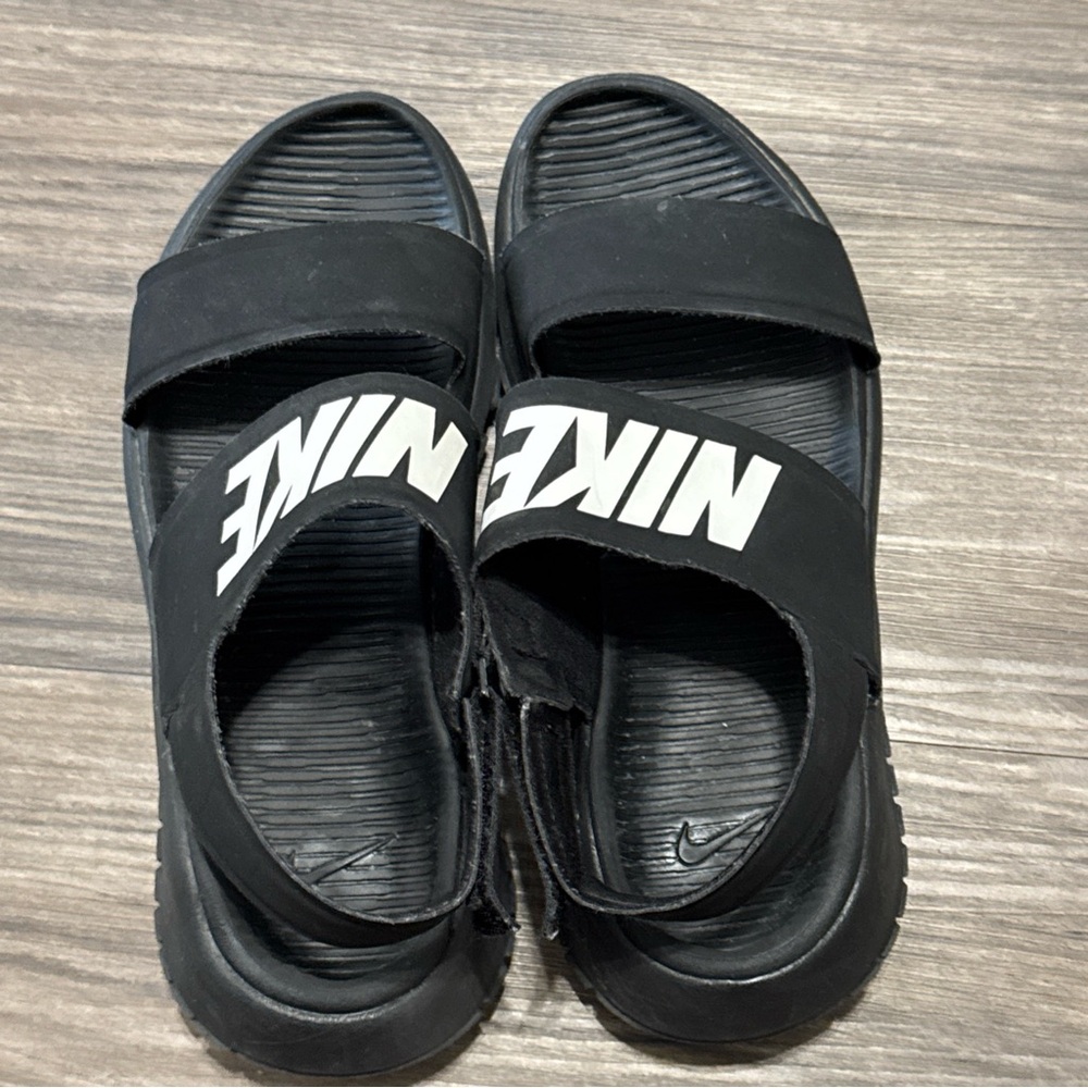 Sleek black slides with bold white Nike logo. Perfect for casual wear.